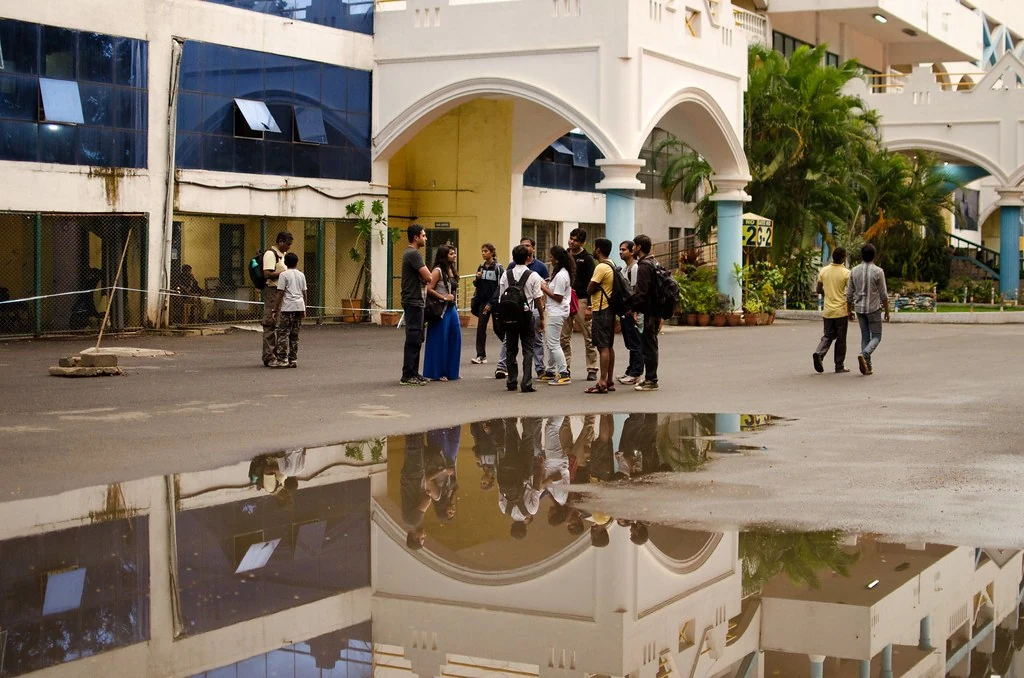 Adventure participants gathering outdoors beside a reflecting puddle.