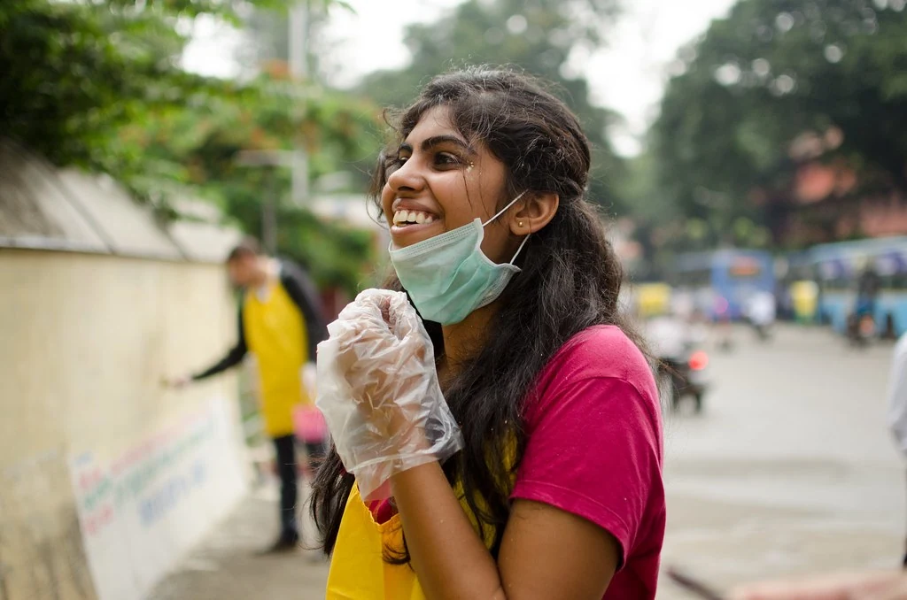 A smiling participant taking part in a community painting activity.