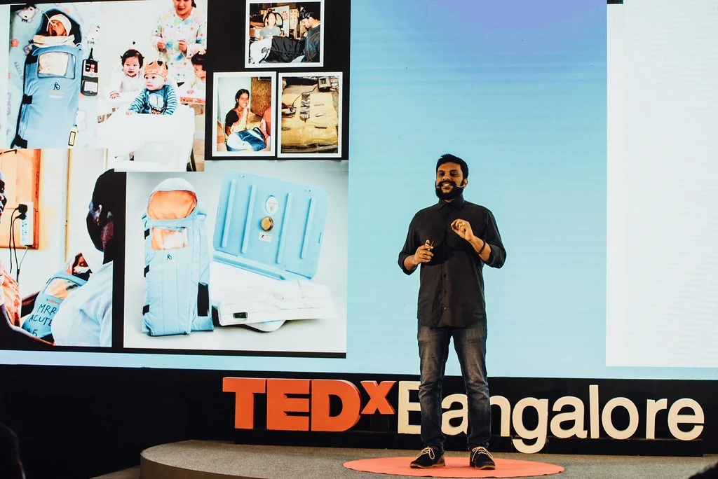 A speaker presenting photographs on a large screen at Beyond Resilience.