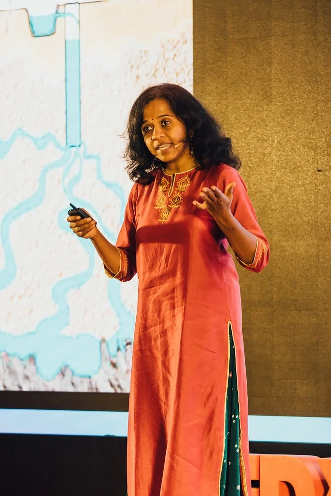A speaker in red gesturing on stage at Beyond Resilience.