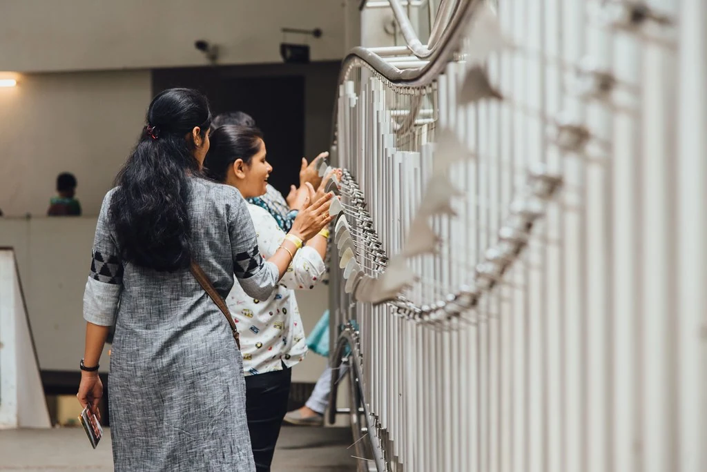 Participants exploring an interactive sound exhibit at Indian Music Experience.