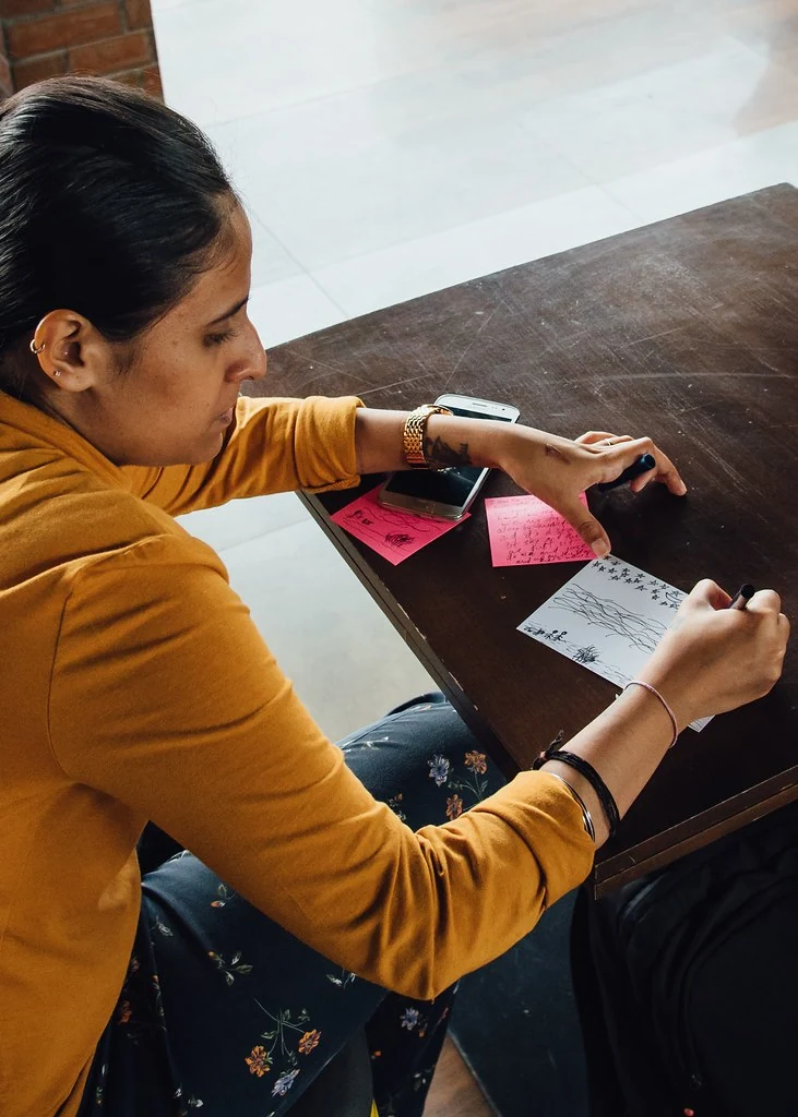 A participant writing a postcard at Letters to My Future Self.