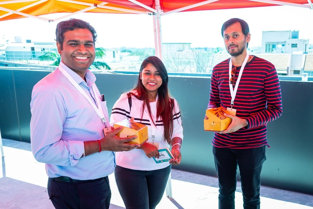 Three attendees smiling together at Nudge.