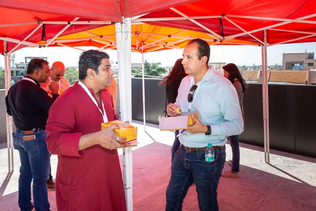Two attendees talking beneath the canopy at Nudge.