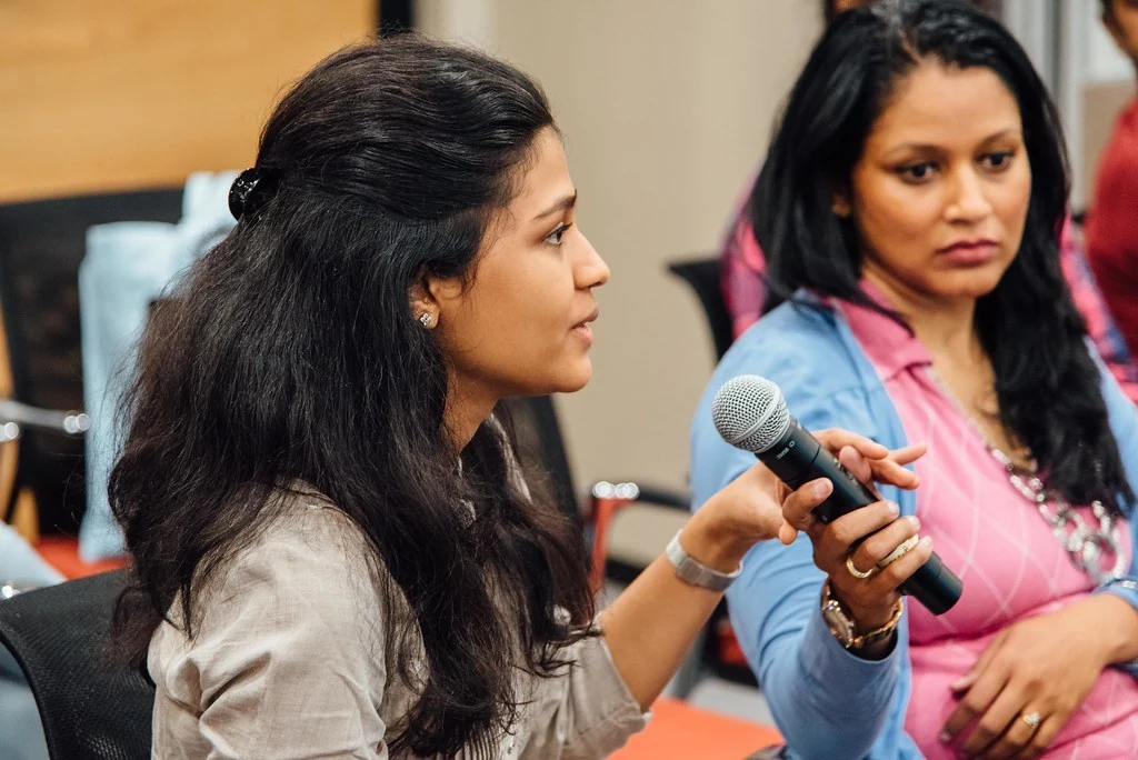 A participant speaking into a microphone during the Power Dressing discussion.