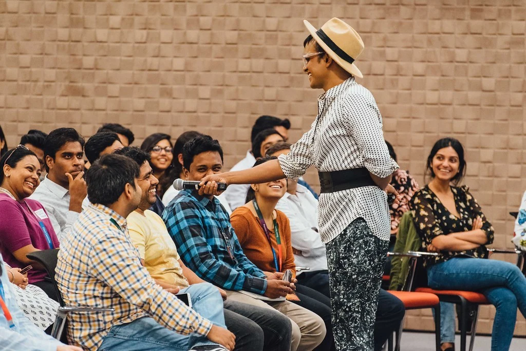 A facilitator speaking among seated participants during Power Dressing.