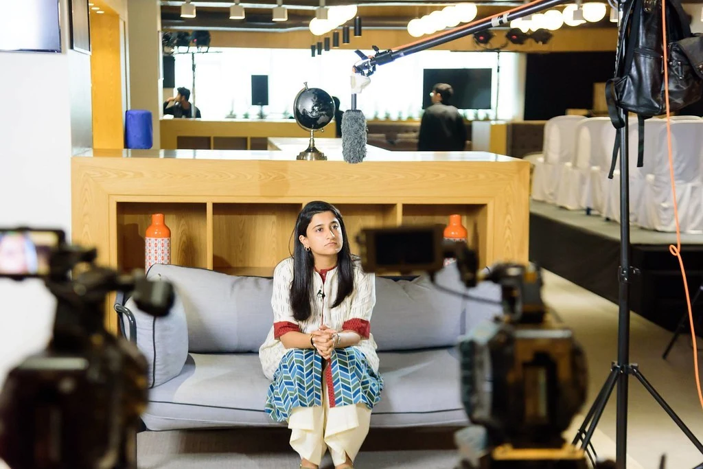 A participant seated for a filmed conversation at Purpose & Progress.