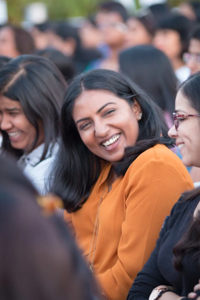 A smiling audience member in an orange wrap at TEDxBangaloreWomen.