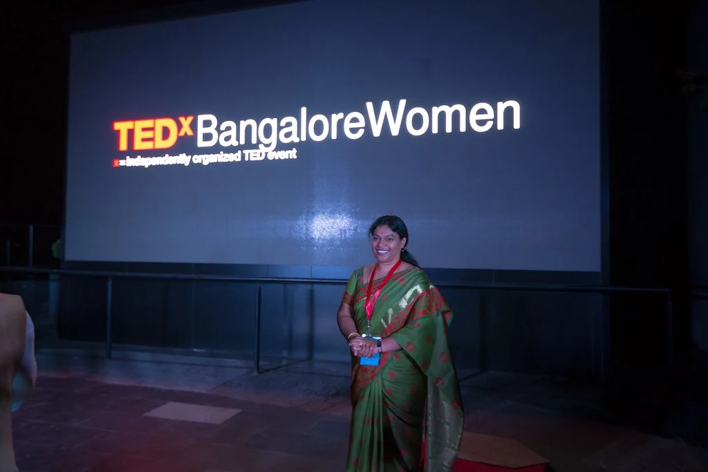 A speaker presenting in front of the event screen at TEDxBangaloreWomen.