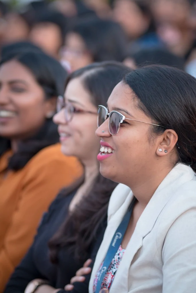 An audience member listening and smiling at TEDxBangaloreWomen.