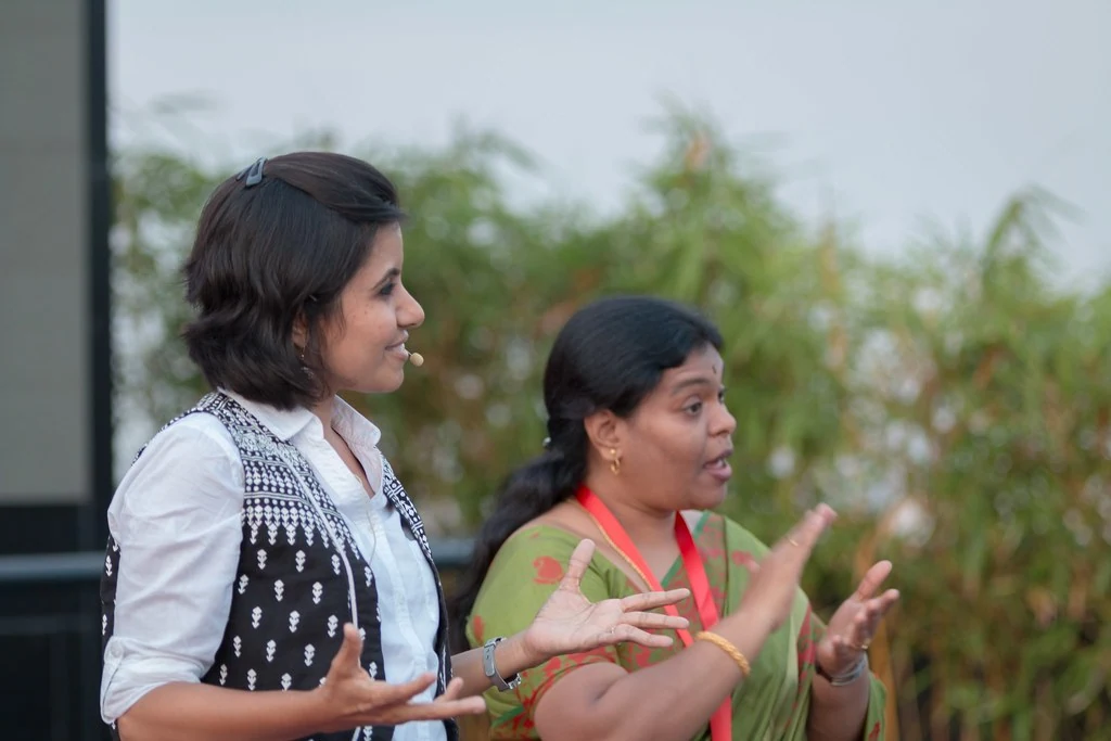Two women in conversation beside the event space at TEDxBangaloreWomen.